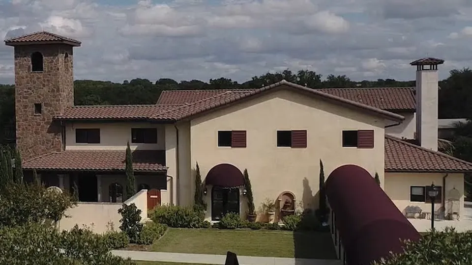 Aerial view of Ma Maison's stone tower and grounds in Dripping Springs