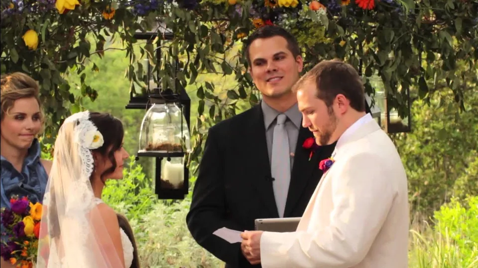 An outdoor ceremony under a flower covered arch at Vista West Ranch