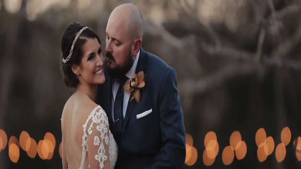 Taryn and Michael close together with warm lights behind them at Pecan Springs Ranch, a still from Adam Grumbo's film
