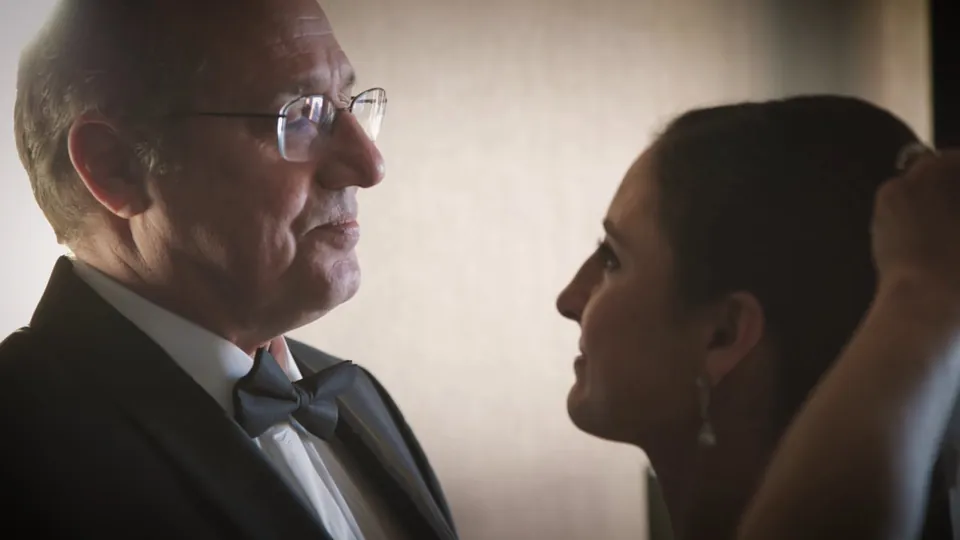 A man in glasses and a bow tie beside a woman seen in profile, a still from Adam Grumbo's film of Denise and Michael's wedding