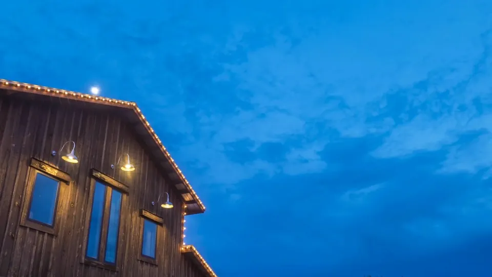 The Lone Oak Barn glowing under a deep blue evening sky, a still from Adam Grumbo's film of Hunter and Kelti's wedding